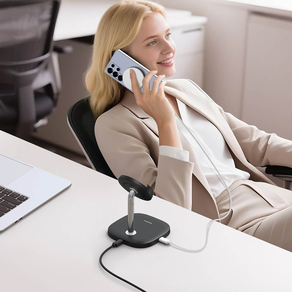 Woman is on a phone call while charging her Samsung phone with a detachable charging pad.